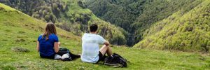 Young couple of hikers taking a break to admire the scenery during a hike in the mountains